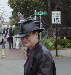 Me in a cloudy and wet P-town. I'm wearing a black leather hat and black leather trench and am in front of a "Speed Limit 15" sign, which Karin Kallmaker, who took the picture, found amusing.